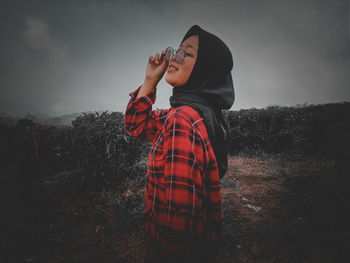 Man photographing on field against sky