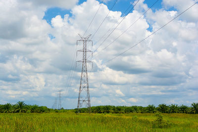 Low angle view of electricity pylon on field against sky