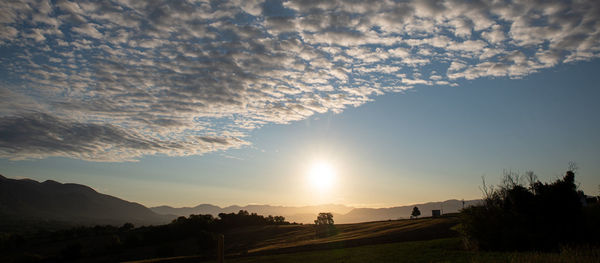 Scenic view of silhouette mountains against sky at sunset