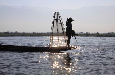 Man standing in lake against sky