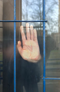 Midsection of person seen through glass window of building