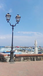 View of street light by sea against sky