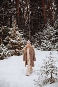 Winter photo of a young woman in a snow-covered forest