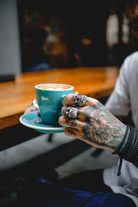 Close-up of hand holding coffee cup