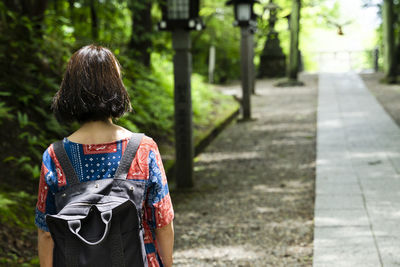 Rear view of woman walking on footpath