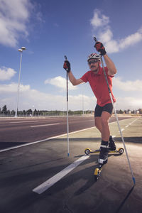 Man with ski rolling on road