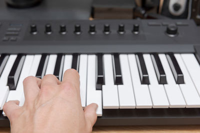 Close-up of hand playing piano