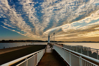 Pier over sea against sky during sunset