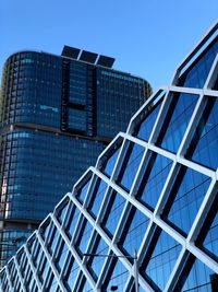 Low angle view of modern building against blue sky