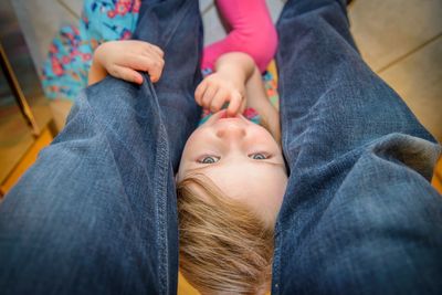 Midsection of girl sitting amidst father legs