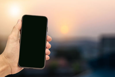 Cropped hand holding mobile phone