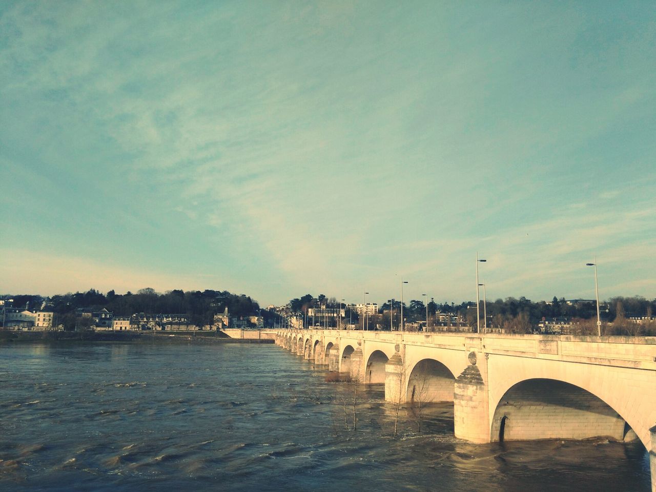 water, built structure, architecture, connection, sky, bridge - man made structure, transportation, river, bridge, building exterior, the way forward, street light, railing, sea, cloud - sky, waterfront, outdoors, diminishing perspective, arch, city