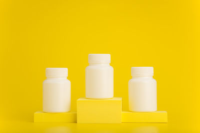 Close-up of bottles against yellow background
