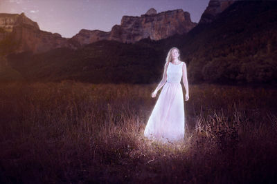 Mid section of woman standing on field against sky