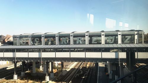 Train on bridge in city against sky