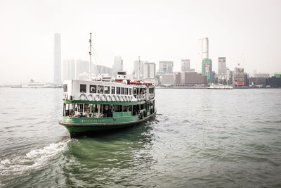 Boats in river with buildings in background