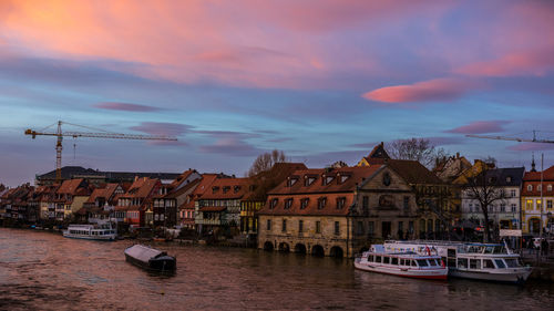 Boats in river with city in background