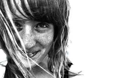 Portrait of happy girl with freckles against white background