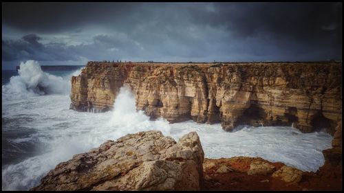 Scenic view of rocks in sea against sky