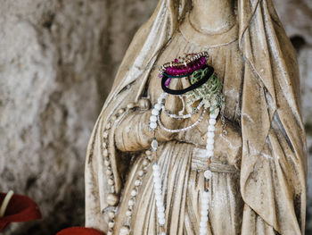 Close-up of virgin mary statue with religious offering