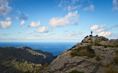 Rock formations by sea against blue sky