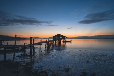 Pier over sea against sky during sunset