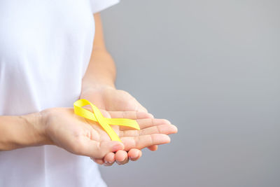 Close-up of woman holding hands over white background