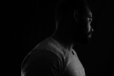 Portrait of young man against black background