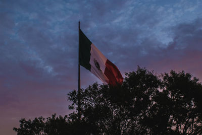 Low angle view of flag against sky at sunset