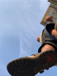 Low angle view of man holding umbrella against sky