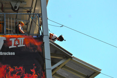 Low angle view of man working at construction site against clear sky