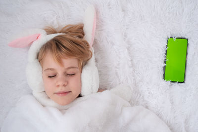 High angle view of girl sleeping on bed