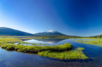 Scenic view of mt bachelor and sparks lake against clear blue sky