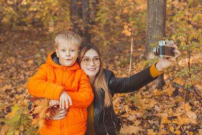 Mother doing selfie with son during autumn