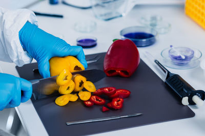 Cropped hands of scientist experimenting on bell peppers