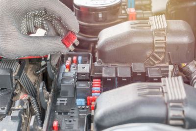 Cropped image of hands holding tool on vehicle