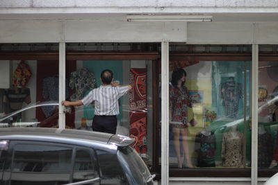 Full length of man standing by window at store