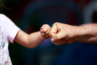 Cropped image of father and child clenching fists