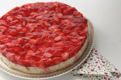 High angle view of strawberry cake in plate and napkin on table
