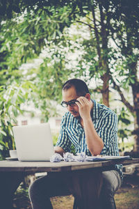 Man using laptop while sitting at table