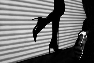 Shadow of woman's legs in high heels