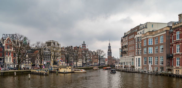 Panoramic view of buildings by river against sky