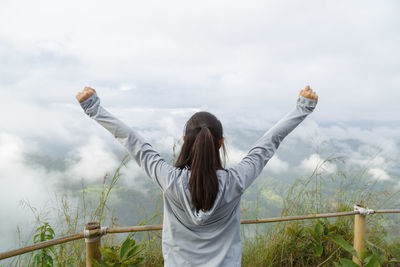 Rear view of woman standing against sky