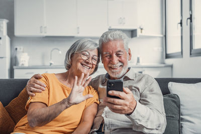 Young woman using mobile phone while sitting at home