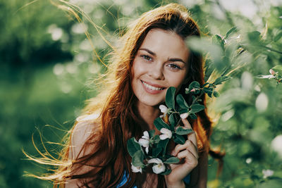 Portrait of young woman sitting on field