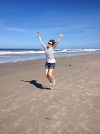 Full length of woman jumping at beach 