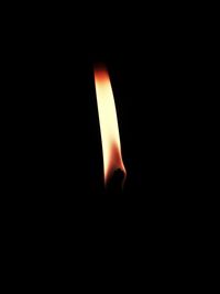 Close-up of lit candle in darkroom