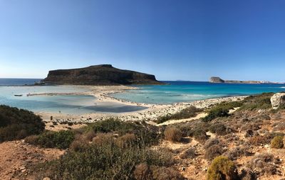 Scenic view of beach against clear blue sky