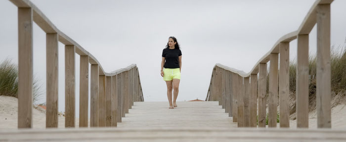 Full length of woman walking on footbridge