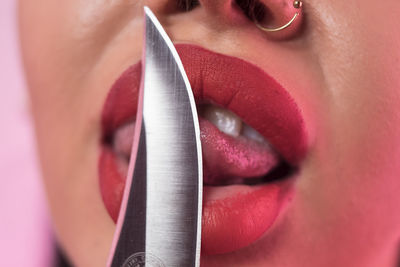 Cropped image of woman licking knife